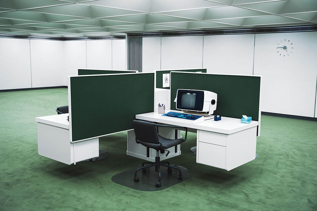 Workstations, where the four core “innies” work at sorting numbers into files to no discernable end, are clustered in the middle of the office and outfitted with round, retro computers. The cubicles are surrounded by the ever-present bare white walls and green carpeting, drenched in fluorescent light, with no windows, and a low ceiling to suggest both a playground and a claustrophobic menace.