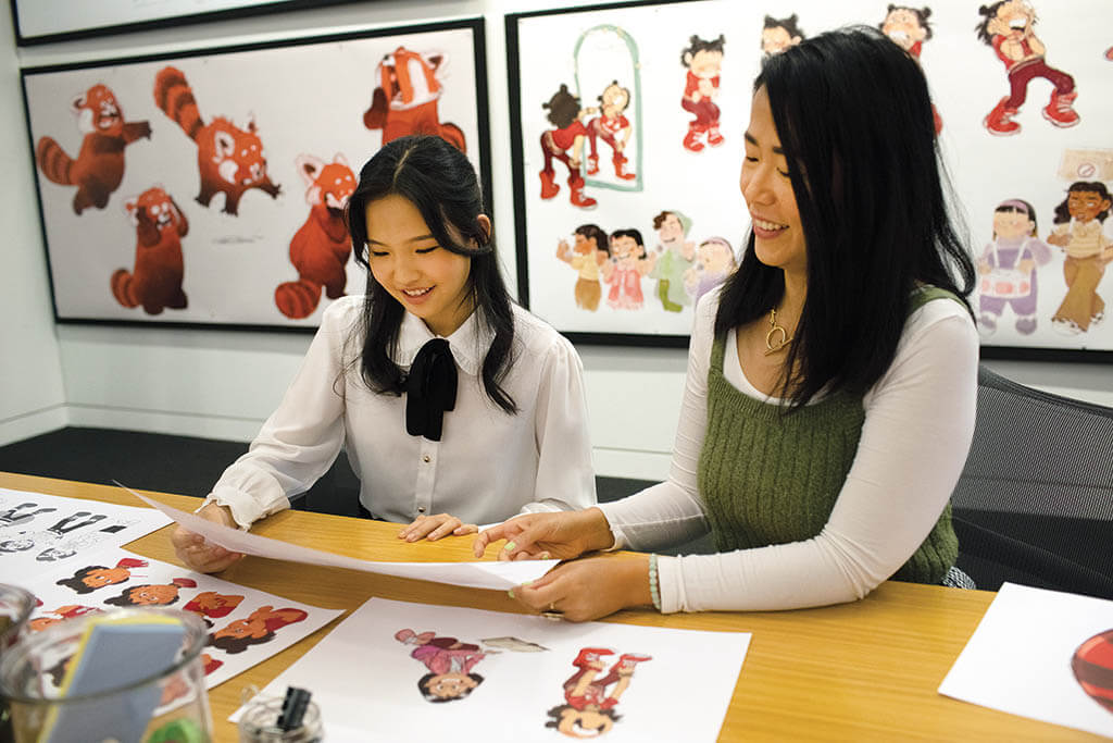 Rosalie Chiang and Shi look over some character designs of Mei Lee for Turning Red.