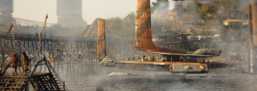 BOTTOM TWO: The Floating Village in “New Asia” was built into a riverbank at a idyllic location in Thailand where there was a village by the river. To make it look more post-apocalyptic, abandoned industrial buildings were added to the background hills. 